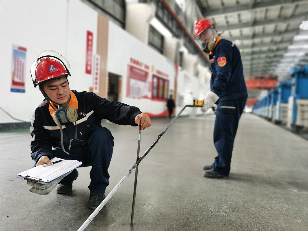 图为云铝淯鑫员工在进行电解槽铝水平与电解质水平测定。沈琼 摄